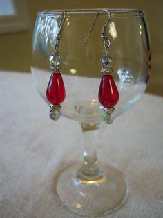 "Beautiful handmade drop earrings measure 2 1/8\" long. The earrings are in a silver tone setting and feature a red center drop bead with silver tone and iridescent beads on top and bottom. These earrings have a lot of sparkle and would dress up any outfit." Nickel Free Red Crystal Earrings For Parties, Red Sterling Silver Beaded Earrings, Elegant Red Teardrop Beaded Earrings, Red Sterling Silver Drop Crystal Earrings, Red Sterling Silver Crystal Drop Earrings, Elegant Red Czech Glass Earrings, Nickel Free Red Drop Earrings, Red Beaded Drop Crystal Earrings, Red Beaded Crystal Drop Earrings