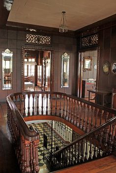 an ornate wooden staircase with wrought iron handrails