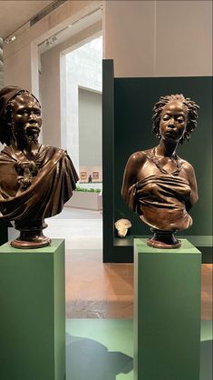 two bronze busturines on pedestals in an art gallery, one with a woman's head