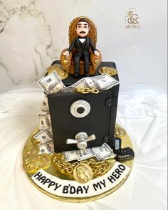 a birthday cake with money and a man sitting in a chair on top of it