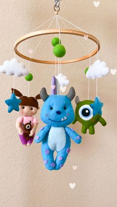 two stuffed animals hanging from a mobile in the shape of a baby's crib