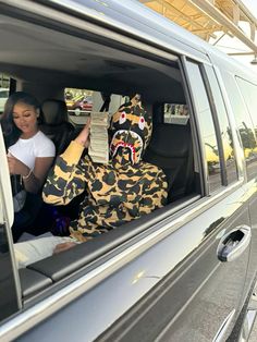 two people in animal costumes sitting in the back of a car