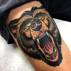 a close up of a tattoo with a lion on it's leg and mouth