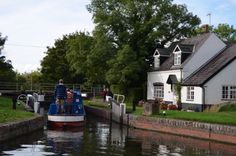 a house on the side of a river next to a boat