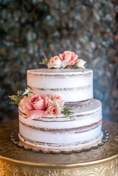 a three tiered cake with flowers on top