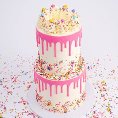 two tiered cake with sprinkles and white frosting