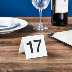 the table is set with wine and place cards