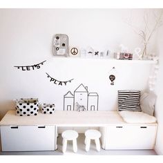 a white room with black and white decorations on the wall, two stools and a shelf