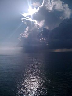 the sun shines through clouds over the ocean