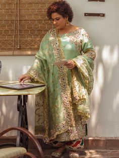 Explore sophistication in a light green raw silk long shirt with full sleeves. Paired with flappers in the same hue, this ensemble is elevated with an organza dupatta in a matching shade. Ideal for Pakistani formal occasions, it exudes timeless elegance and contemporary style.In the realm of attire, emerges a garment adorned in the gentle and refreshing hue of Light Green�a color that invokes the serenity of a spring morning. Meticulously tailored from the luxurious embrace of raw silk fabric, t Embroidery Suits Punjabi, Zardozi Work, Raw Silk Fabric, Classic Outfit, Pakistani Fashion Party Wear, Simple Pakistani Dresses, Organza Dupatta, Embroidery Suits, Silk Dupatta