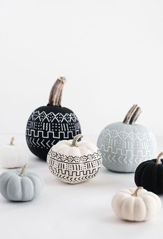 several small pumpkins sitting on top of a white table next to eachother