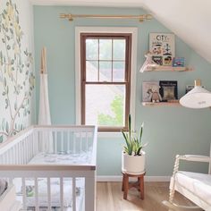 a baby's room with blue walls and white furniture