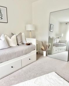 a bedroom with a bed, dresser and mirror