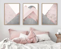 two pink and grey art prints hanging on the wall above a bed in a bedroom