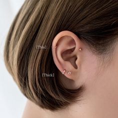 a close up of a person wearing an ear cuff with two piercings on their ears