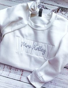 Wifey Sweatshirt-Wife Sweatshirt-Engagement Gift-Wedding Gift-Future Mrs Sweatshirt-Mrs Sweatshirt-Bride Sweatshirt-Embroidered Sweatshirt-Custom Embroidered Sweatshirt-Wife Sweatshirt-Wedding Gift for Her Custom Wifey Sweatshirt Embroidered with your choice of FUTURE, BRIDE, WIFEY or WIFE. This unisex sized custom sweatshirt is super soft and makes an elegant Wifey sweatshirt for you to wear or a wonderful engagement gift for any Wifey or Future Mrs! Perfect for a Bachelorette Party or to wear White Fitted Tops With Custom Embroidery, White Long Sleeve Top With Custom Embroidery, White Tops With Embroidered Text For Fall, White Long Sleeve Sweatshirt With Letter Embroidery, White Winter Top With Embroidered Text, White Embroidered Text Top For Winter, Fitted White Tops With Embroidered Text, White Embroidered Top For Winter, White Fitted Cotton Sweatshirt