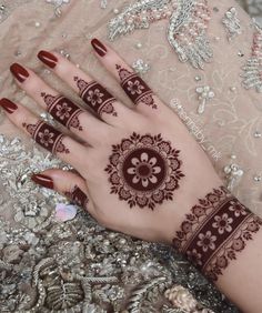 a woman's hand with henna tattoos on it