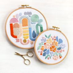 two embroidery hoops with scissors on top of them