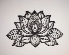 an intricately designed metal wall hanging on a white wall