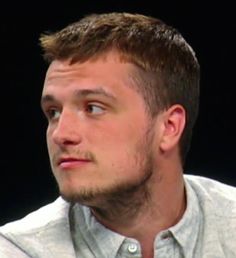 a close up of a person wearing a white shirt and looking off to the side