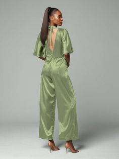 This soft satin jumpsuit features a flattering v-neck design, making it the perfect choice for mothers of the bride. Its dress pantsuit style provides comfort and elegance, while its high-quality material ensures a polished look. Stay stylish and comfortable on that special day with our jumpsuit. Chic Satin V-neck Jumpsuits And Rompers, Elegant Satin Jumpsuits And Rompers For Workwear, Elegant Satin Jumpsuit Or Romper In Solid Color, Chic Satin Jumpsuits And Rompers With V-neck, Formal Satin V-neck Jumpsuit, Elegant V-neck Spring Pantsuit, Spring Satin Jumpsuits And Rompers In Solid Color, Fitted V-neck Jumpsuit For Wedding Guests, Elegant V-neck Evening Pantsuit