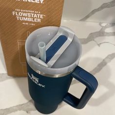 a blue coffee mug sitting next to a box