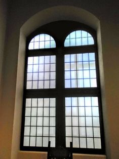 an open window in a white wall with black frame and glass panes on the windowsill