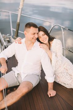 a man and woman sitting on the deck of a boat