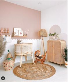 a room with pink walls, wicker furniture and other items on the floor in it