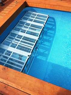 an above ground swimming pool with metal grates on the bottom and blue water in it