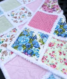 a patchwork quilt with blue flowers and pink polka dots on the bottom, sitting on a table