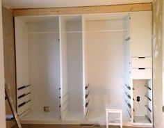 an empty room with white walls and drawers in it's closets that are being built