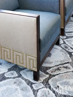 a blue chair sitting on top of a rug next to a wooden frame with studded trim