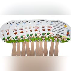 a group of wooden clothes pins with pictures of houses and trees on them, sitting in front of a white background