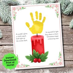 a christmas card with a handprint on it and holly wreaths around the edges