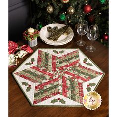 a christmas table setting with wine glasses and silverware