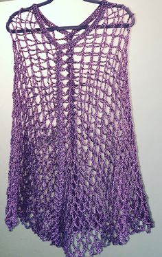 a purple crocheted top hanging on a wall