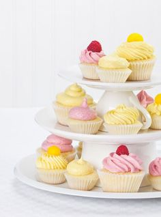 three tiered trays with cupcakes and muffins on them, all decorated in different colors