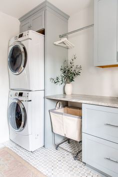 a washer and dryer sitting in a kitchen next to each other on top of cabinets