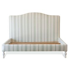 an upholstered bed frame with striped fabric and wooden slats on the headboard