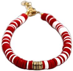 a red and white striped bracelet with gold accents on it's end, sitting against a white background