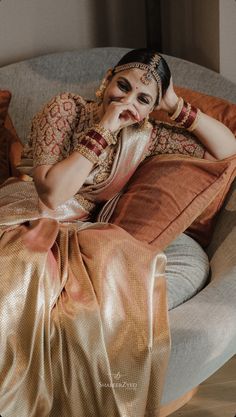 a woman sitting on top of a couch in a dress