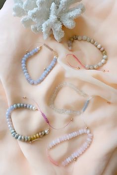 several bracelets and a flower on a table