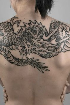 a woman with a dragon tattoo on her back