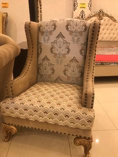 a chair with an upholstered back and gold trimmings on the legs