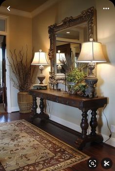 a large mirror sitting on top of a wooden table next to a lamp and rug