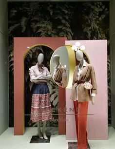 two mannequins in front of a mirror with different outfits on display at the same time