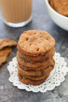 a stack of cookies sitting on top of a doily next to a glass of milk