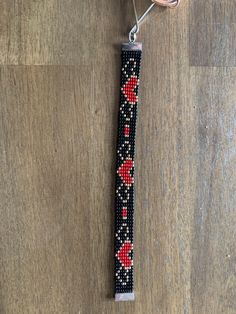 a black and red beaded keychain with hearts on it