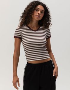 Full Tilt V-Neck Baby Tee. Ribbed Knit Construction. Allover Stripe Print. V-Neckline. Short Sleeve. Shrunken Fit. 57% Cotton, 38% Polyester, 5% Spandex. Machine Wash. Imported. Model Is Wearing A Size Small. Model Measurements:height: 5'7" Bust: 32cwaist: 24"hips: 35" Ribbed V-neck Elastane Top, Sporty Fitted Top With Ribbed Neckline, Striped Stretch V-neck Top, Ribbed Cotton V-neck T-shirt, Sporty V-neck Top, Sporty Striped V-neck Top, Sporty Tops With Ribbed Neckline And Stretch Fit, Sporty Stretch Top With Ribbed Neckline, Stretch V-neck Tops With Ribbed Neckline